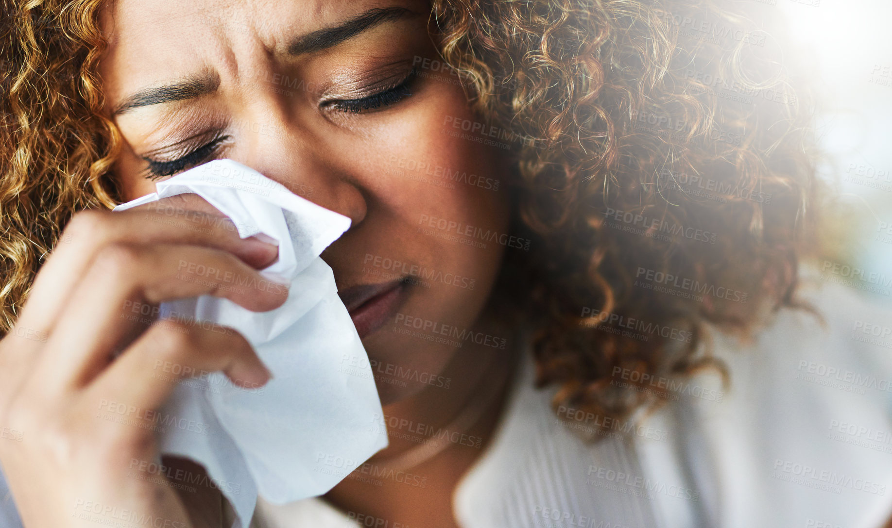 Buy stock photo Closeup of a frustrated businesswoman using a tissue to wipe her nose while being seated in the office