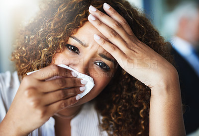 Buy stock photo Closeup of a frustrated businesswoman using a tissue to wipe her nose while being seated in the office