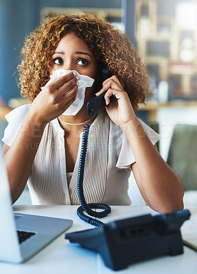 Buy stock photo Shot of a frustrated businesswoman blowing her nose and answering the phone while being seated in the office