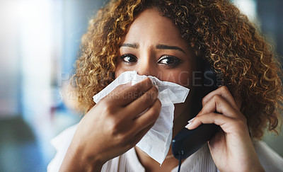 Buy stock photo Shot of a frustrated businesswoman blowing her nose and answering the phone while being seated in the office