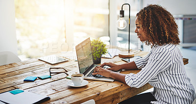 Buy stock photo Cropped shot of a woman using her laptop on a wooden table