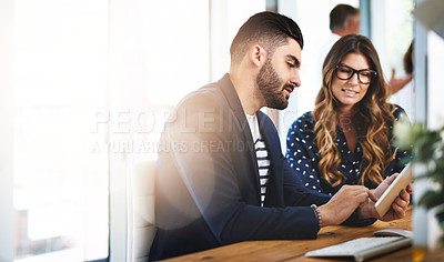 Buy stock photo Shot of colleagues working together on a digital tablet in an office