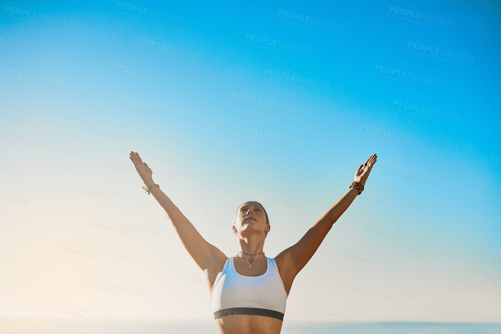 Buy stock photo Shot of an athletic young woman practicing yoga on the beach