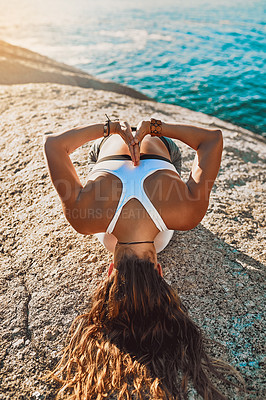Buy stock photo Shot of a young woman practicing yoga on the beach