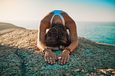 Buy stock photo Shot of a woman practising the child pose at then beach