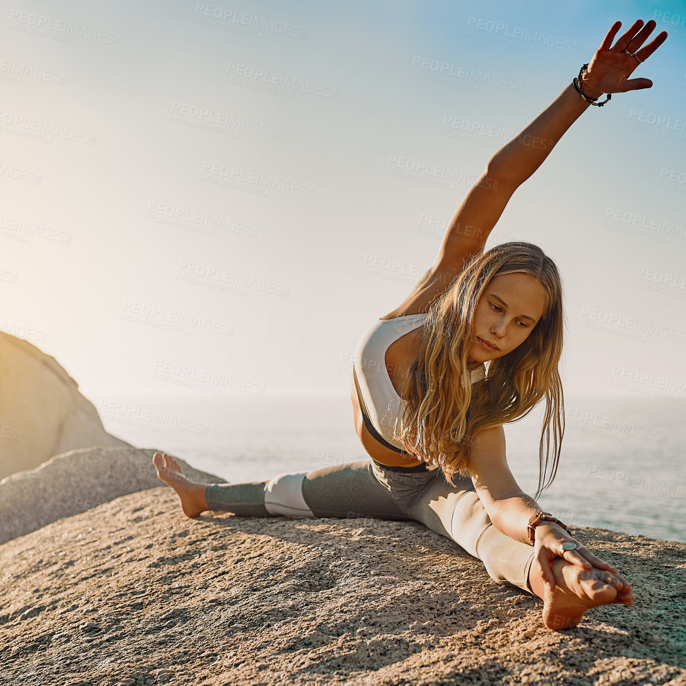 Buy stock photo Shot of an athletic young woman practicing yoga on the beach