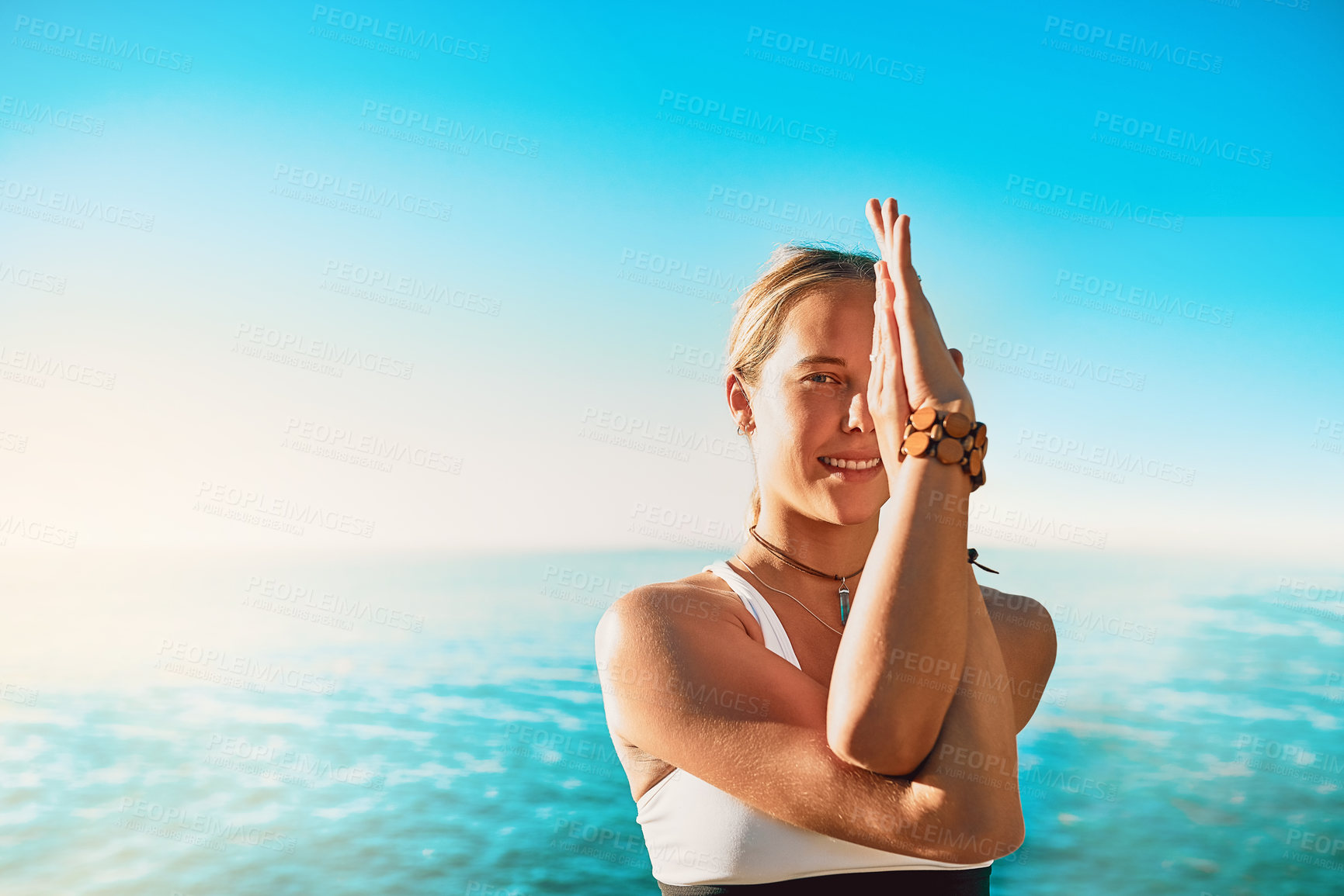 Buy stock photo Shot of an athletic young woman practicing yoga on the beach