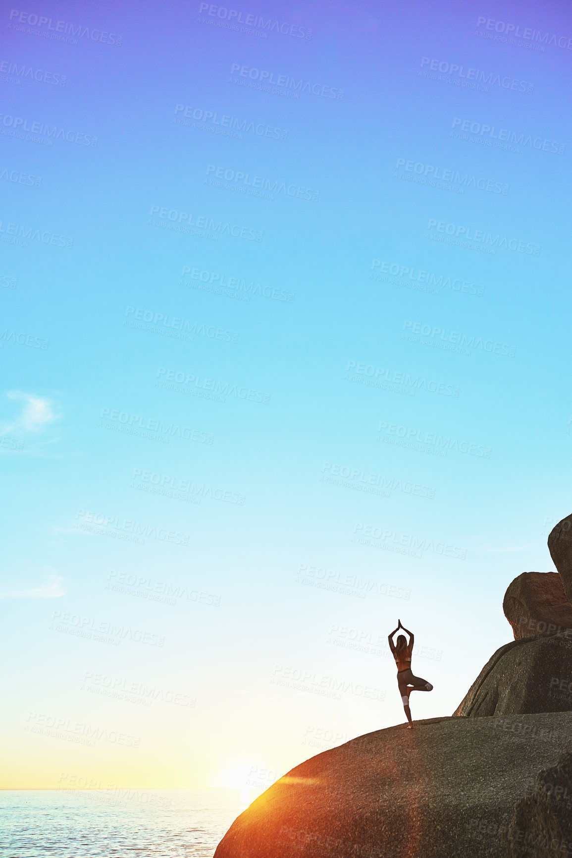 Buy stock photo Shot of an athletic young woman practicing yoga on the beach