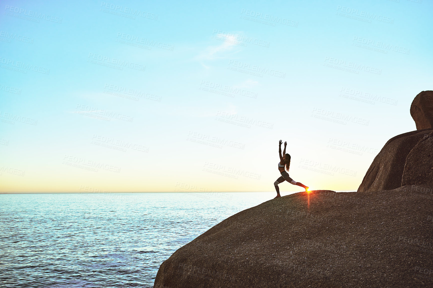 Buy stock photo Shot of an athletic young woman practicing yoga on the beach