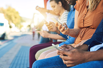 Buy stock photo Shot of a group unrecognizable people using their phones outside during the day