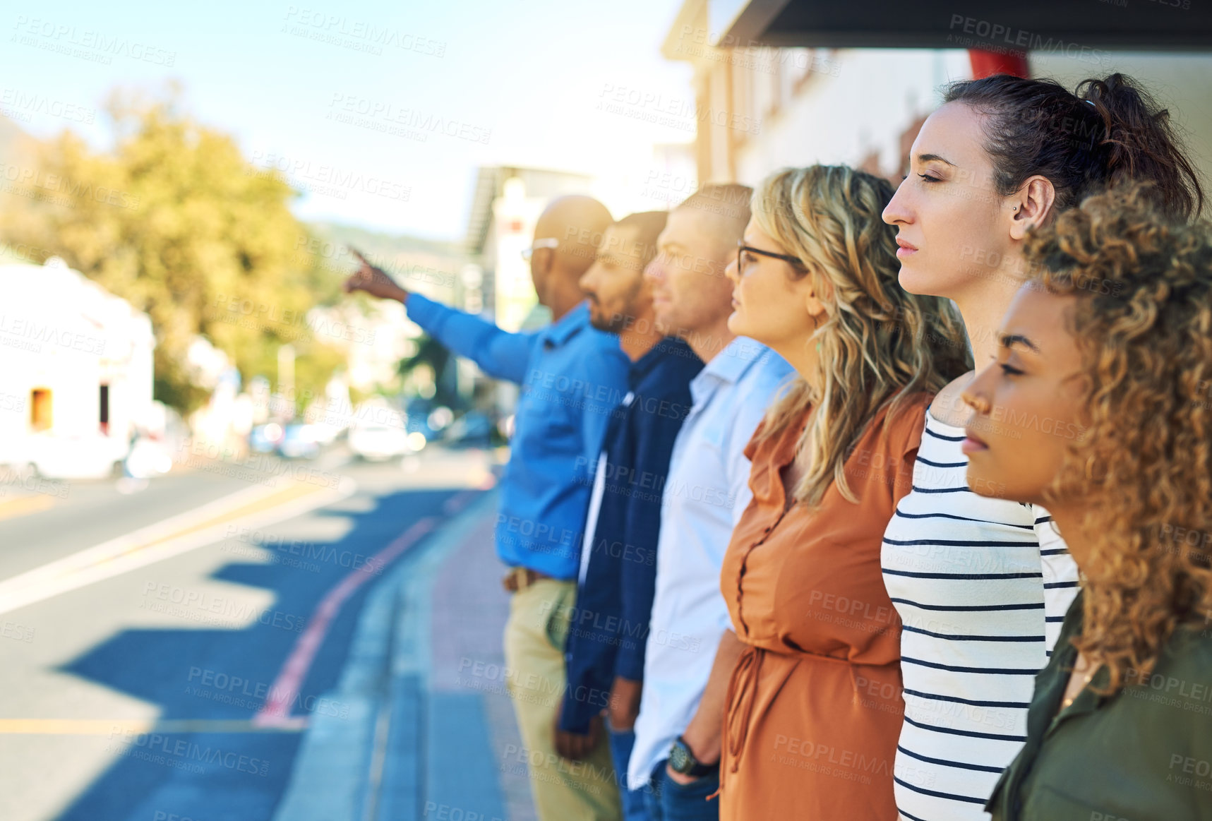 Buy stock photo Shot of a group friends standing and looking into the distance next to a street outside