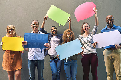 Buy stock photo Shot of a cheerful group of young friends holding up signs while standing together outside