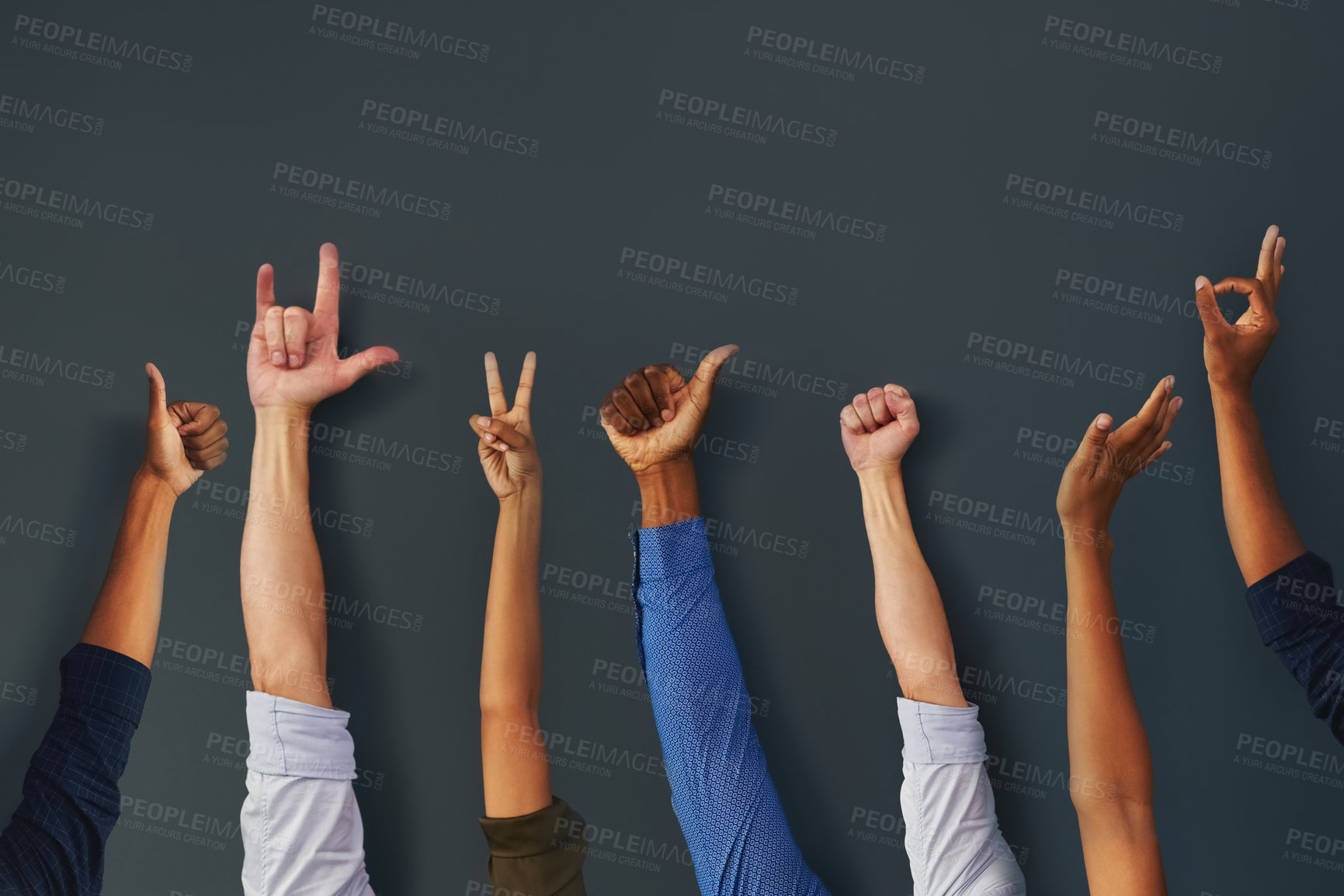 Buy stock photo Shot of a group unrecognizable people holding up their hands and showing different types of hand gestures inside a building