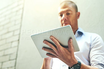 Buy stock photo Businessman working on a tablet, reading quick email message online or checking company SEO website data while waiting outside. Mature corporate professional browsing internet on wireless technology