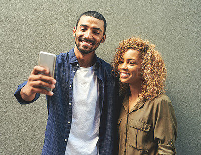 Buy stock photo Shot of a young couple taking a selfie together outside