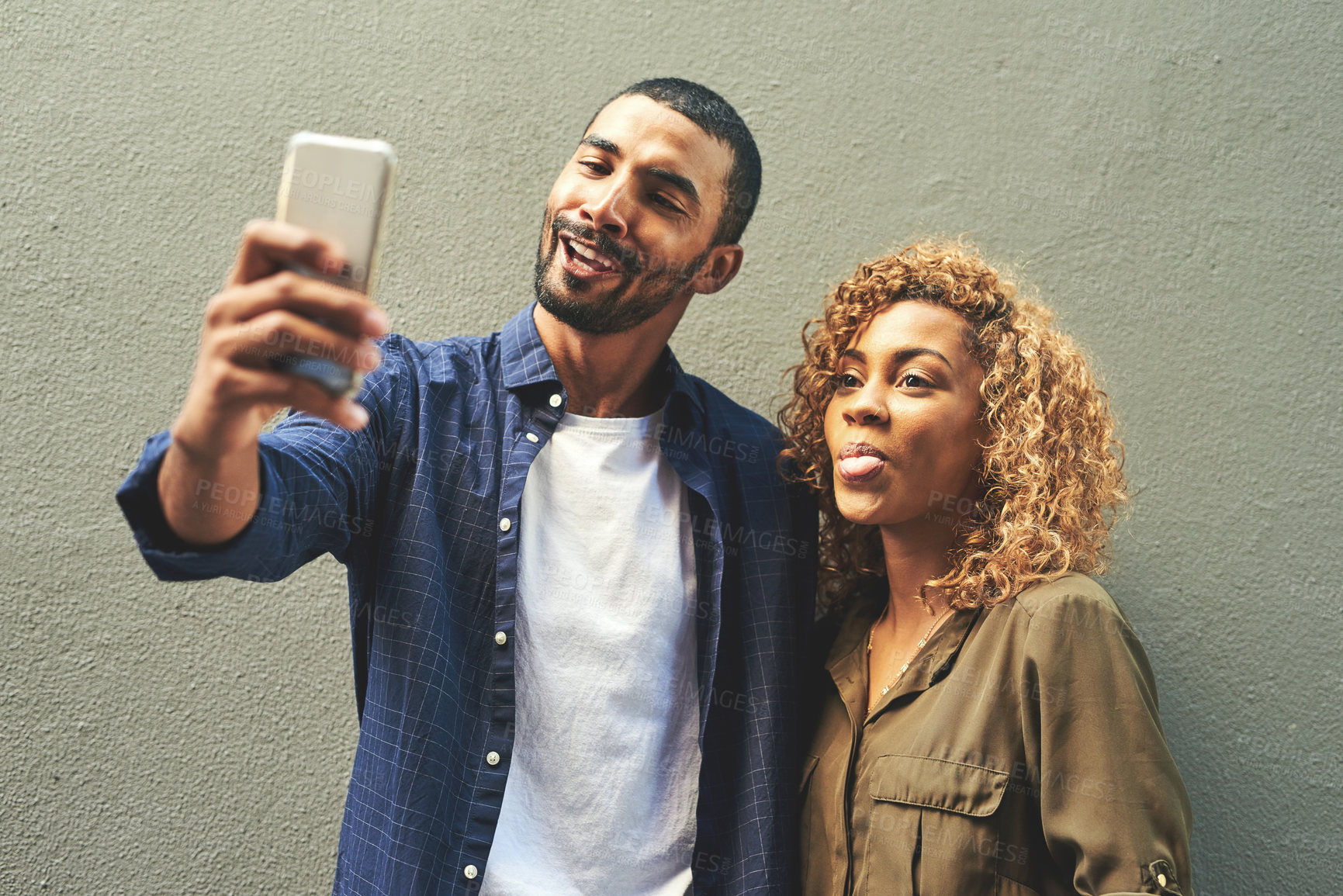 Buy stock photo Shot of a young couple taking a selfie together outside