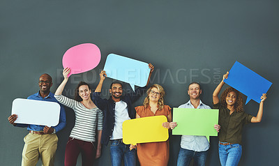 Buy stock photo Smiling casual team of diverse people holding opinion speech bubbles, to voice their important communication message. Creative group standing with colorful copyspace sign boards together in a row