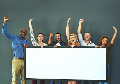 Buy stock photo Studio shot of a diverse group of people holding up a placard against a gray background