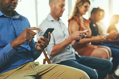 Buy stock photo Casual modern business people texting on social media networking applications, on their digital mobile phones. Group of professionals texting on their cellphones together in a row