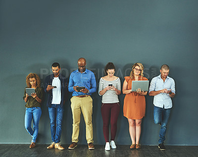 Buy stock photo Diverse group of people browsing social media on a phone, tablet and laptop in studio on a grey background. Networking, surfing the internet and posting online with wireless technology and copyspace