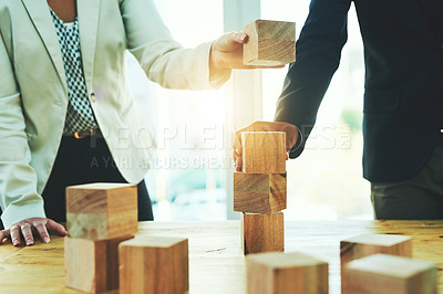 Buy stock photo Teamwork, building blocks and business people in office, design challenge and problem solving at startup. Engineering, architecture and strategy with wood block game, man and woman working together.