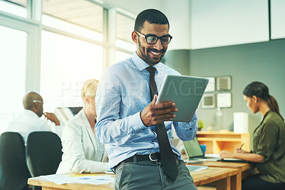 Buy stock photo Shot of a businessman working on a digital tablet in an office