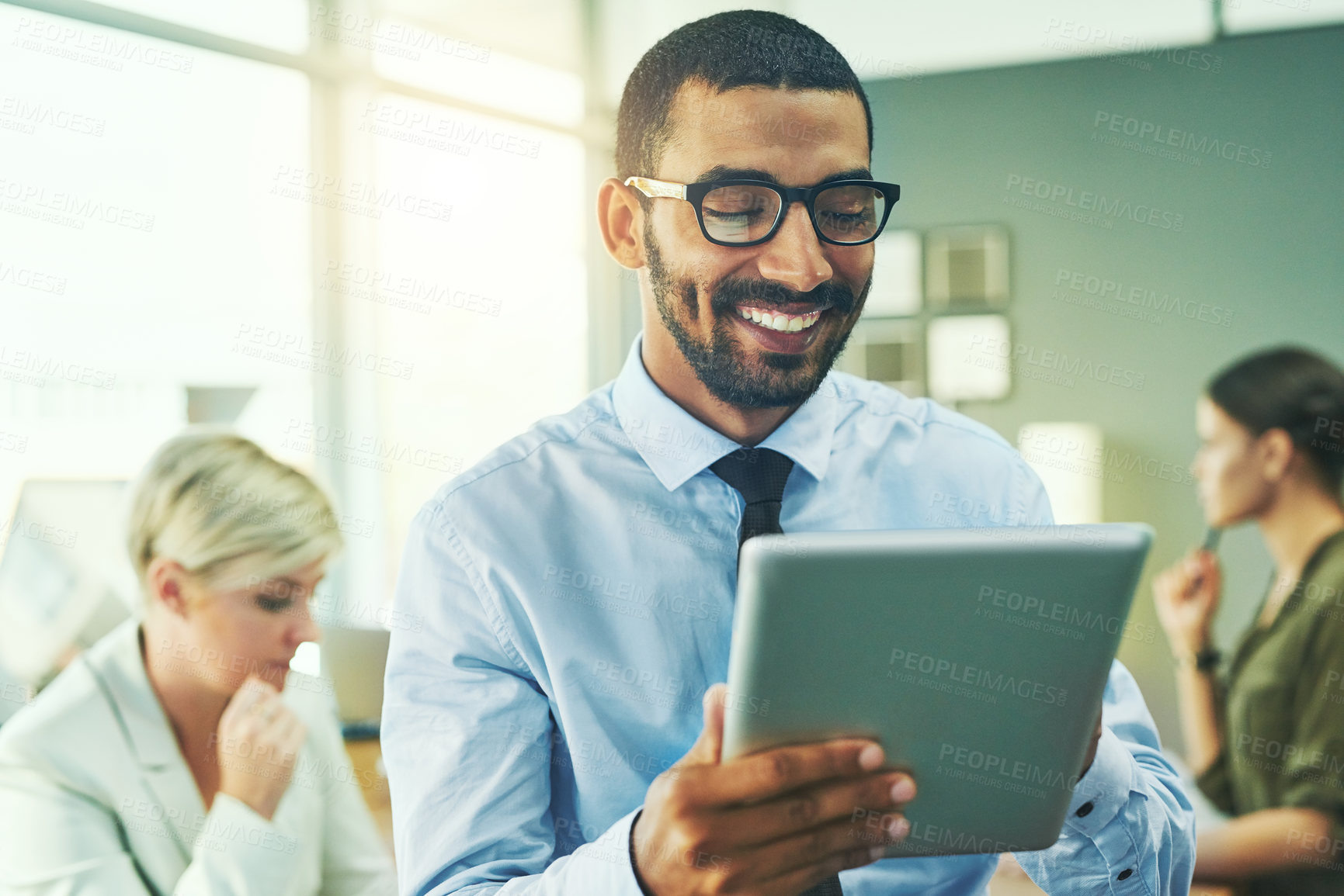 Buy stock photo Shot of a businessman working on a digital tablet in an office