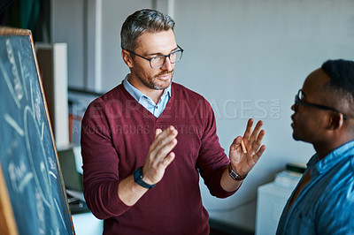 Buy stock photo Shot of two designers brainstorming together in an office
