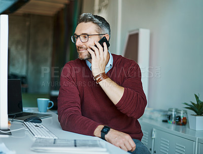 Buy stock photo Shot of a mature businessman talking on a cellphone while working in an office