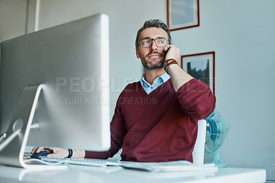 Buy stock photo Shot of a mature businessman talking on a cellphone while working in an office