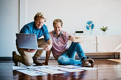 Buy stock photo Shot of two designers brainstorming together on the floor in an office