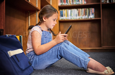 Buy stock photo Shot of a young girl using a digital tablet at school