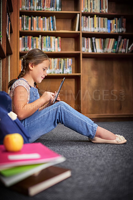 Buy stock photo Library, kid and learning on tablet at school for knowledge, course or online quiz in elementary. Bookshelf, student or girl studying on tech for english test, scroll app or educational game on floor