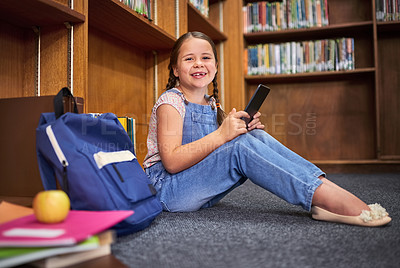 Buy stock photo Library, portrait and happy child learning on tablet at school for knowledge in kindergarten. Bookshelf, student and girl studying on tech for english test, course and educational game on floor in Uk