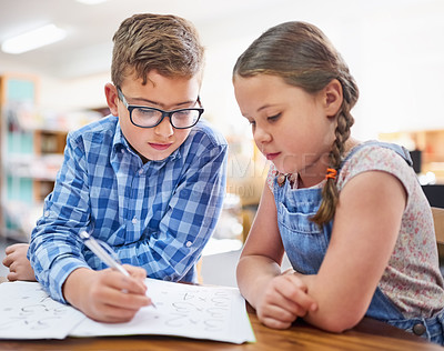 Buy stock photo Shot of two young children working together at school