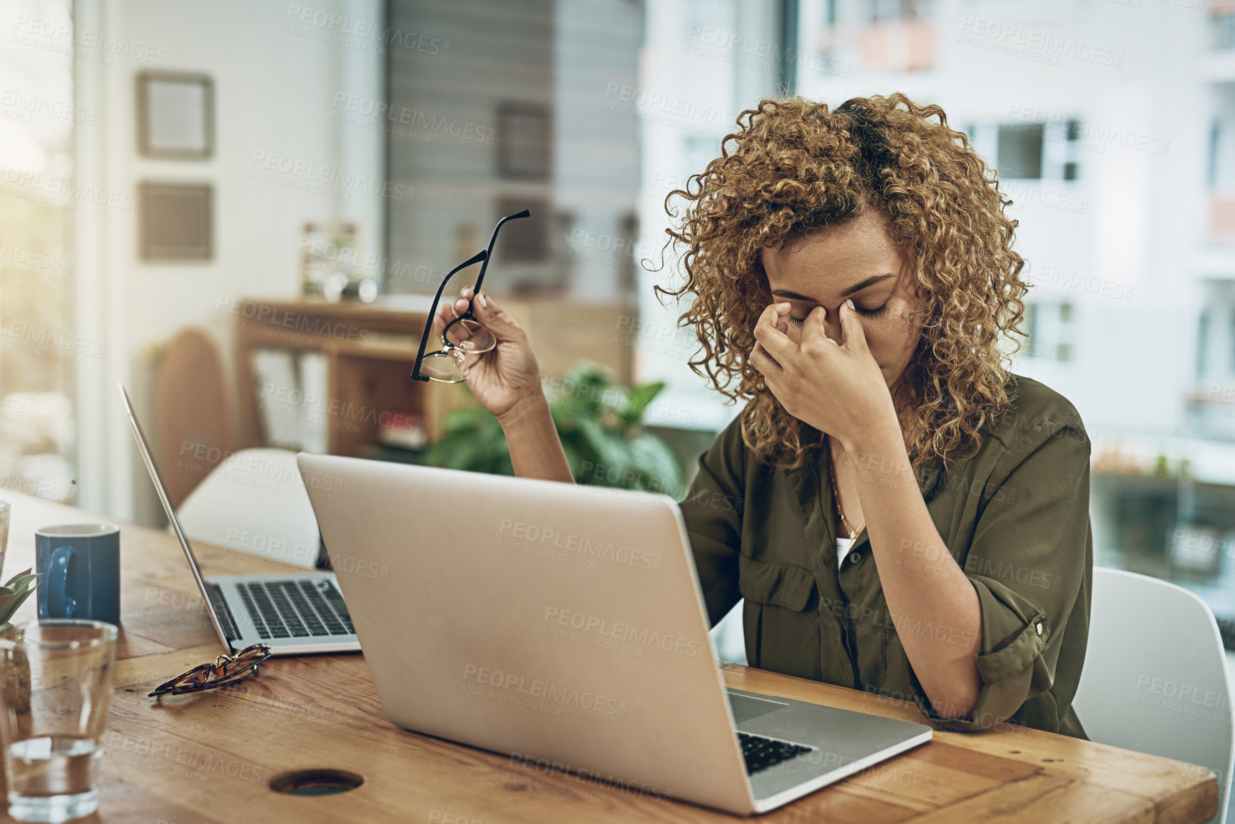 Buy stock photo Shot of a young woman suffering from stress while using a computer at her work desk