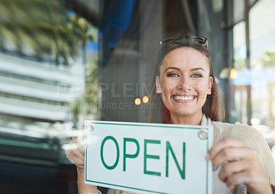 Buy stock photo Portrait of a young entrepreneur holding an “open” sign in her business