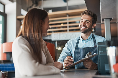 Buy stock photo Shot of two business owners working together in a cafe