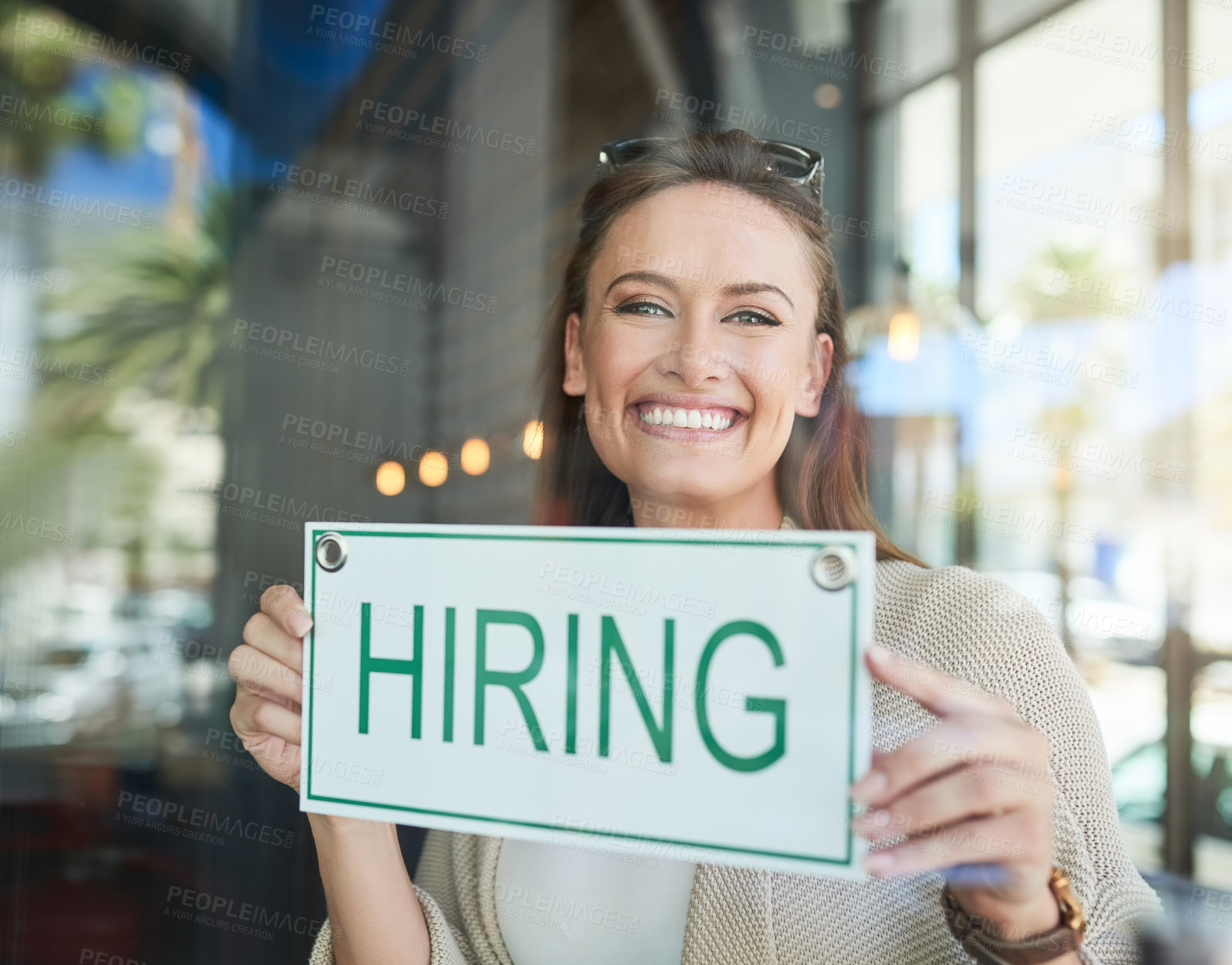 Buy stock photo Portrait of a young entrepreneur holding a “hiring” sign in her business