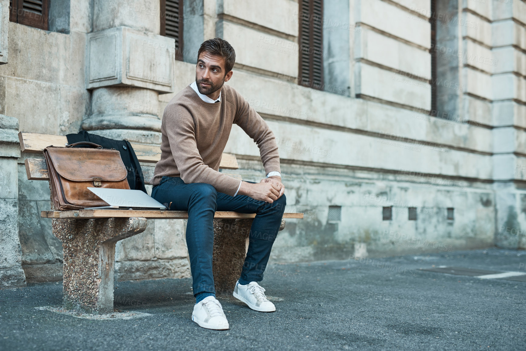 Buy stock photo Full length shot of a handsome businessman sitting on a bench in town