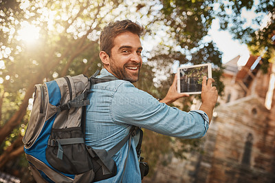 Buy stock photo Cropped shot of a handsome young man taking photographs on his tablet while on vacation