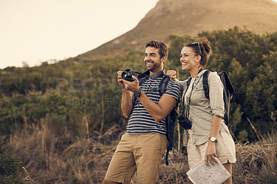Buy stock photo Shot of a couple taking pictures on their camera while out hiking