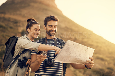 Buy stock photo Shot of a couple looking at a map while out hiking