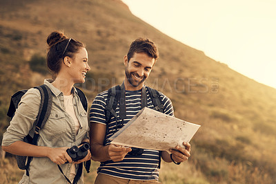 Buy stock photo Shot of a couple looking at a map while out hiking
