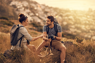 Buy stock photo Shot of a couple looking at pictures on their camera while out on a hiking trip