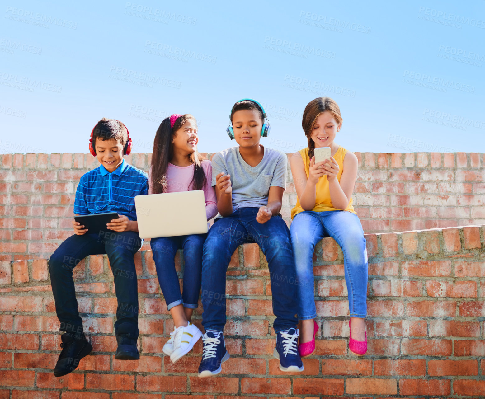 Buy stock photo Shot of a diverse group of children having fun with technology outside