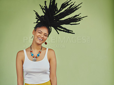 Buy stock photo Studio shot of an attractive young woman tossing her hair against a green background