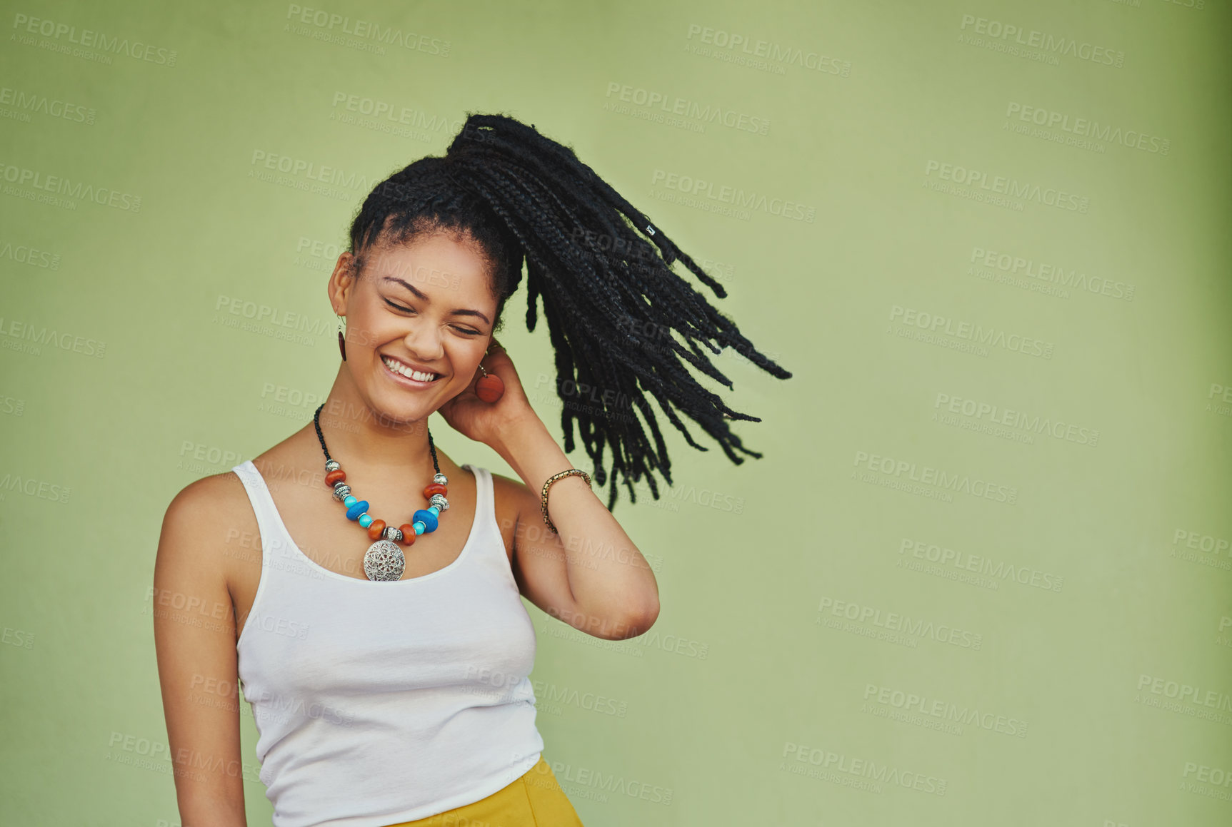Buy stock photo Studio shot of an attractive and trendy young woman posing against a green background