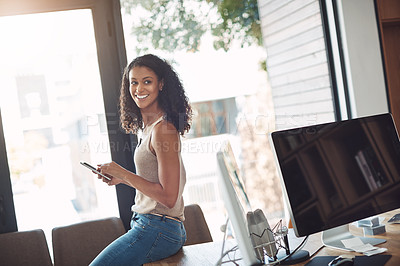 Buy stock photo Casual female holding a phone in a home office enjoying working remote sitting on her desk. Candid, real and authentic moment of digital marketing worker. Smiling woman taking a break on social media