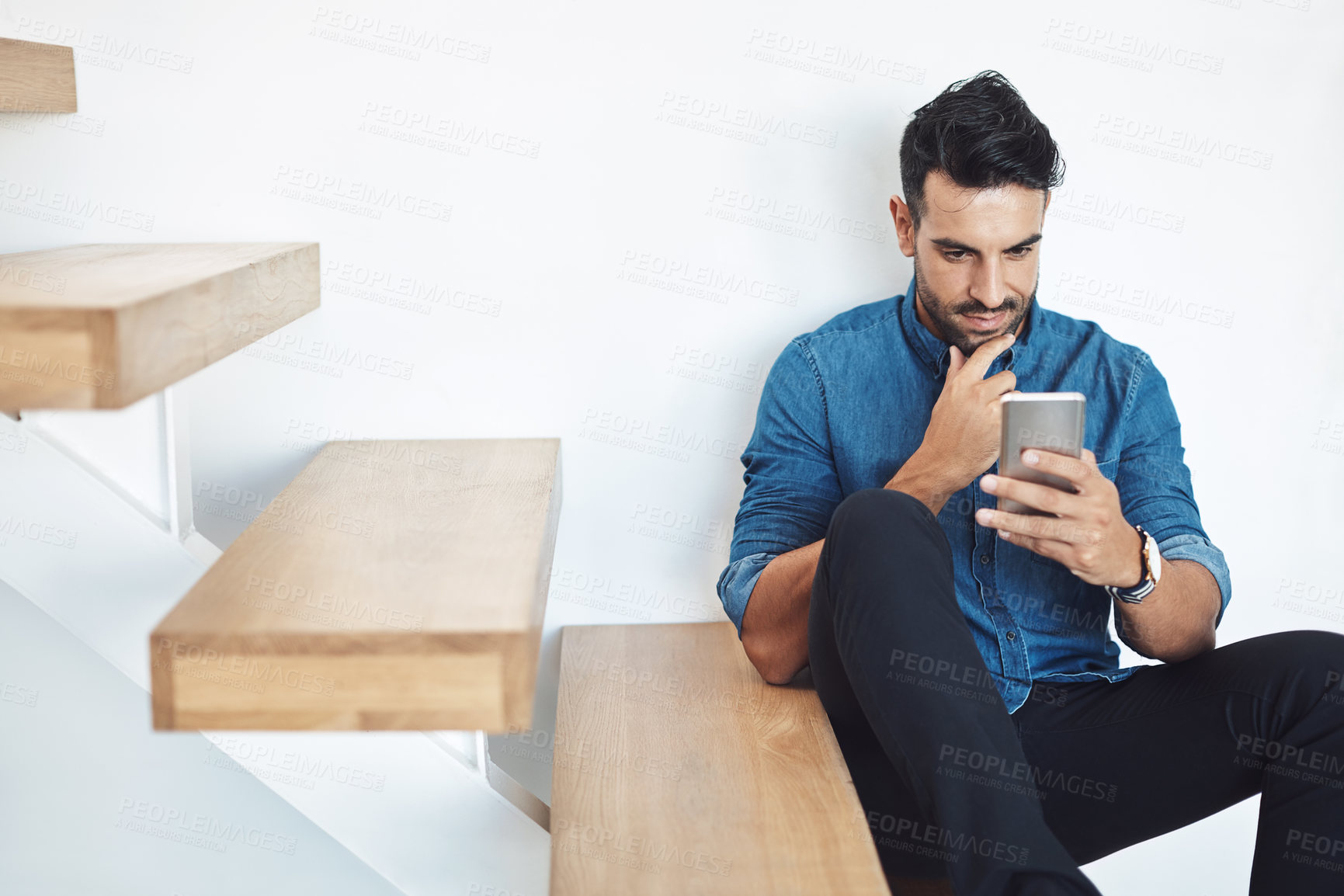 Buy stock photo Male texting on a phone, browsing social media online while sitting on steps. Surfing the internet, Sharing information, networking and staying connected. Updating status and posting feed with an app